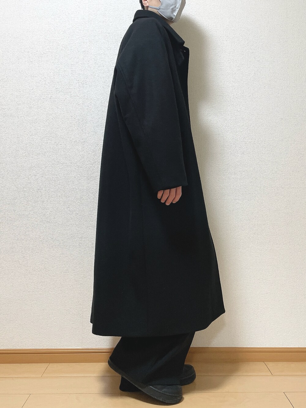 ブラック系のステンカラーコート、ブラック系のニット/セーター、ブラック系のその他パンツを着用したメンズの冬コーディネートの2枚目の写真