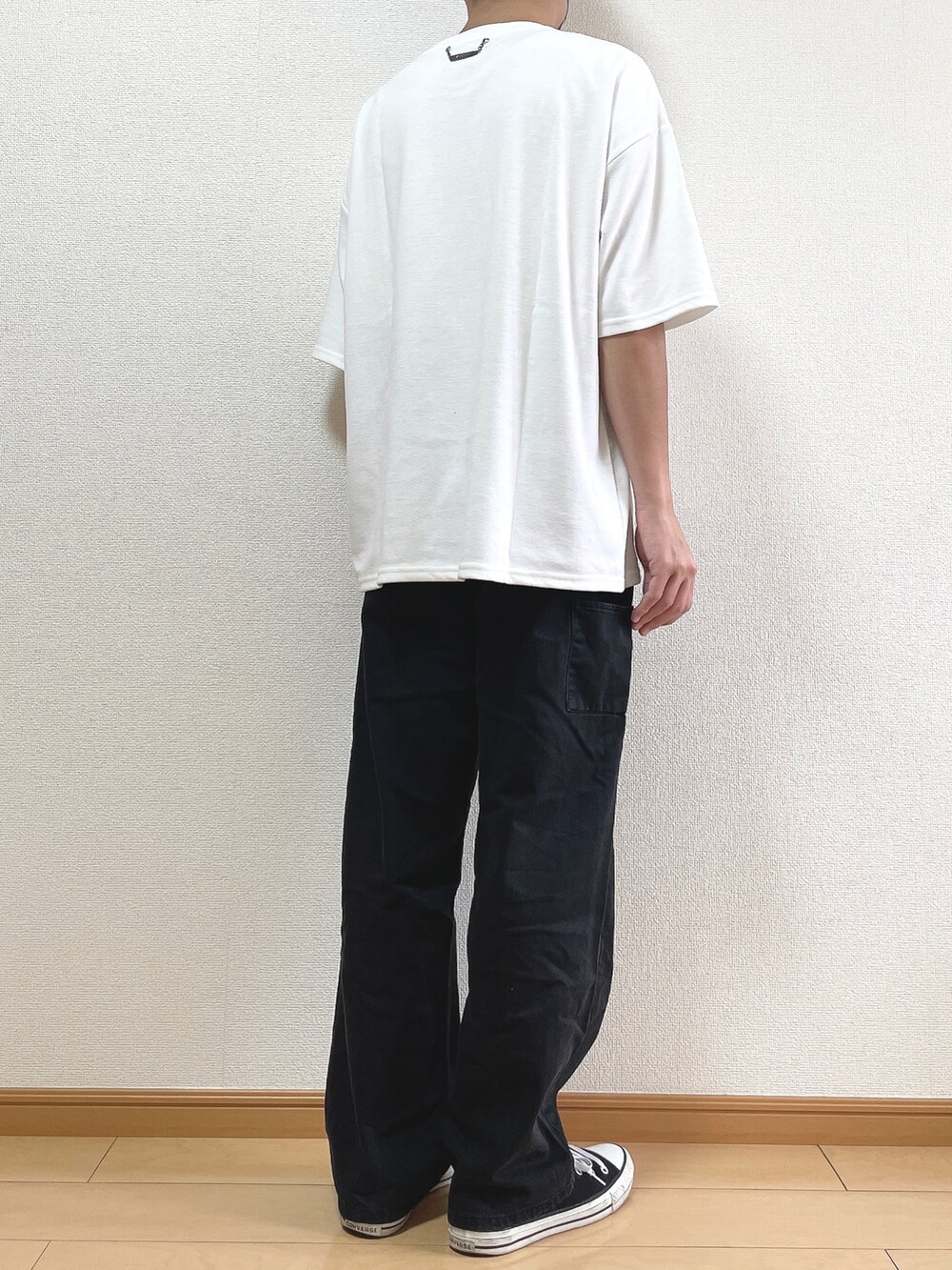 ホワイト系のTシャツ/カットソー、ブラック系のデニムパンツ、ブラック系のスニーカーを着用したメンズの秋コーディネートの4枚目の写真