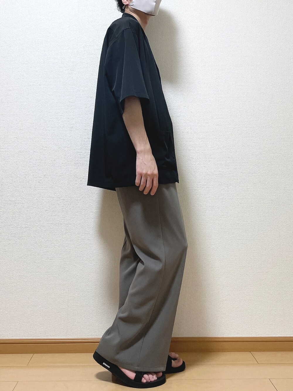 ブラック系のジャケット/アウター、ホワイト系のタンクトップ、ブラウン系のスラックスを着用したメンズの夏コーディネートの2枚目の写真