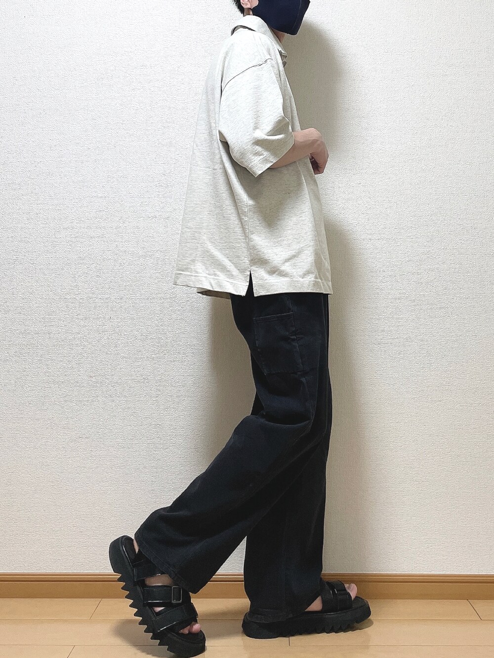 ベージュ系のTシャツ/カットソー、ブラック系のデニムパンツ、ブラック系のサンダルを着用したメンズの春コーディネートの2枚目の写真