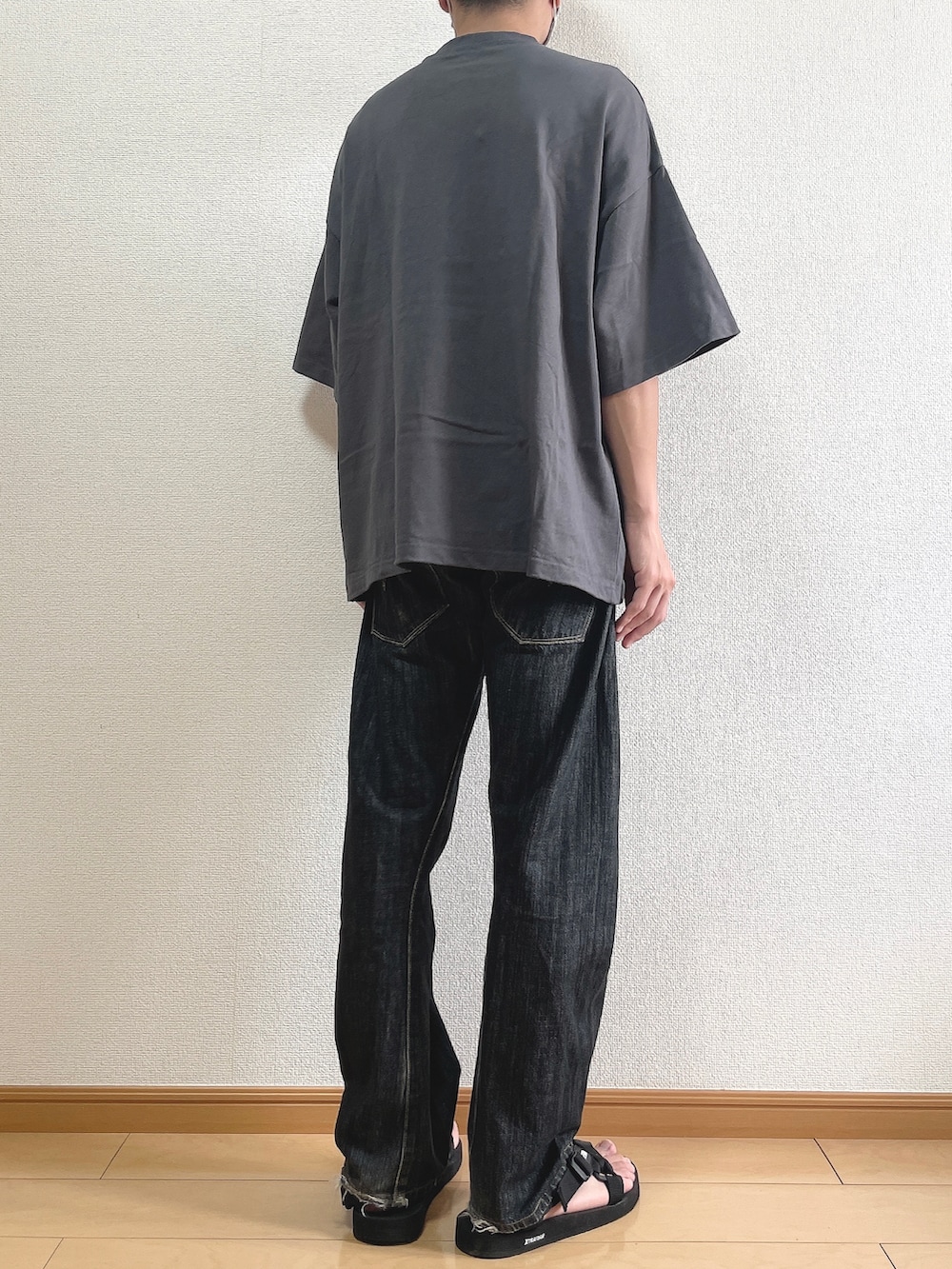グレー系のTシャツ/カットソー、ブラック系のデニムパンツ、ブラック系のサンダルを着用したメンズの夏コーディネートの4枚目の写真