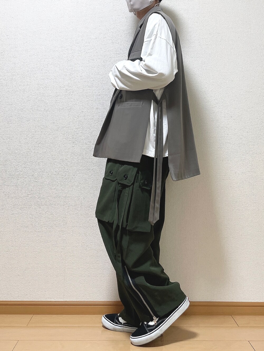 ブラウン系のベスト、ホワイト系のTシャツ/カットソー、グリーン系のカーゴパンツを着用したメンズの春コーディネートの3枚目の写真