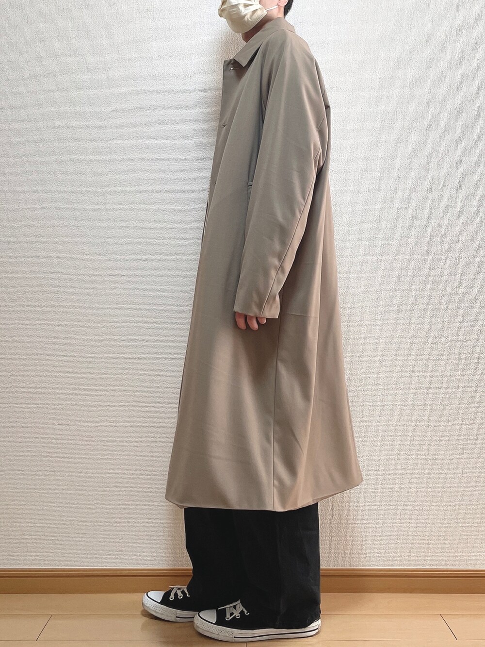 ベージュ系のステンカラーコート、グリーン系のTシャツ/カットソー、ブラック系のデニムパンツを着用したメンズの冬コーディネートの3枚目の写真