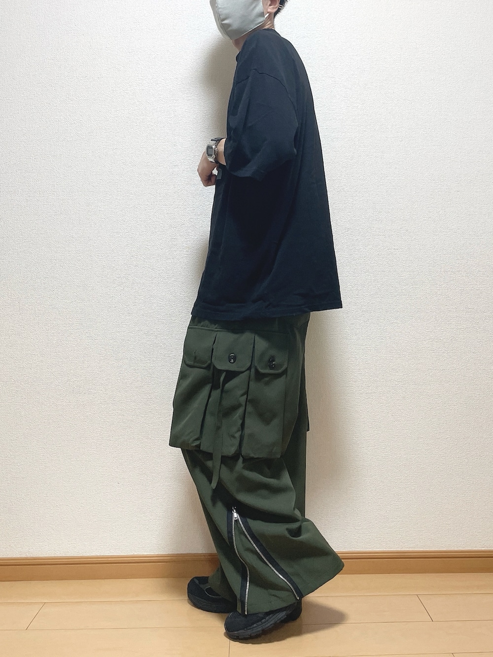 ブラック系のTシャツ/カットソー、グリーン系のカーゴパンツ、ブラック系のスニーカーを着用したメンズの夏コーディネートの3枚目の写真