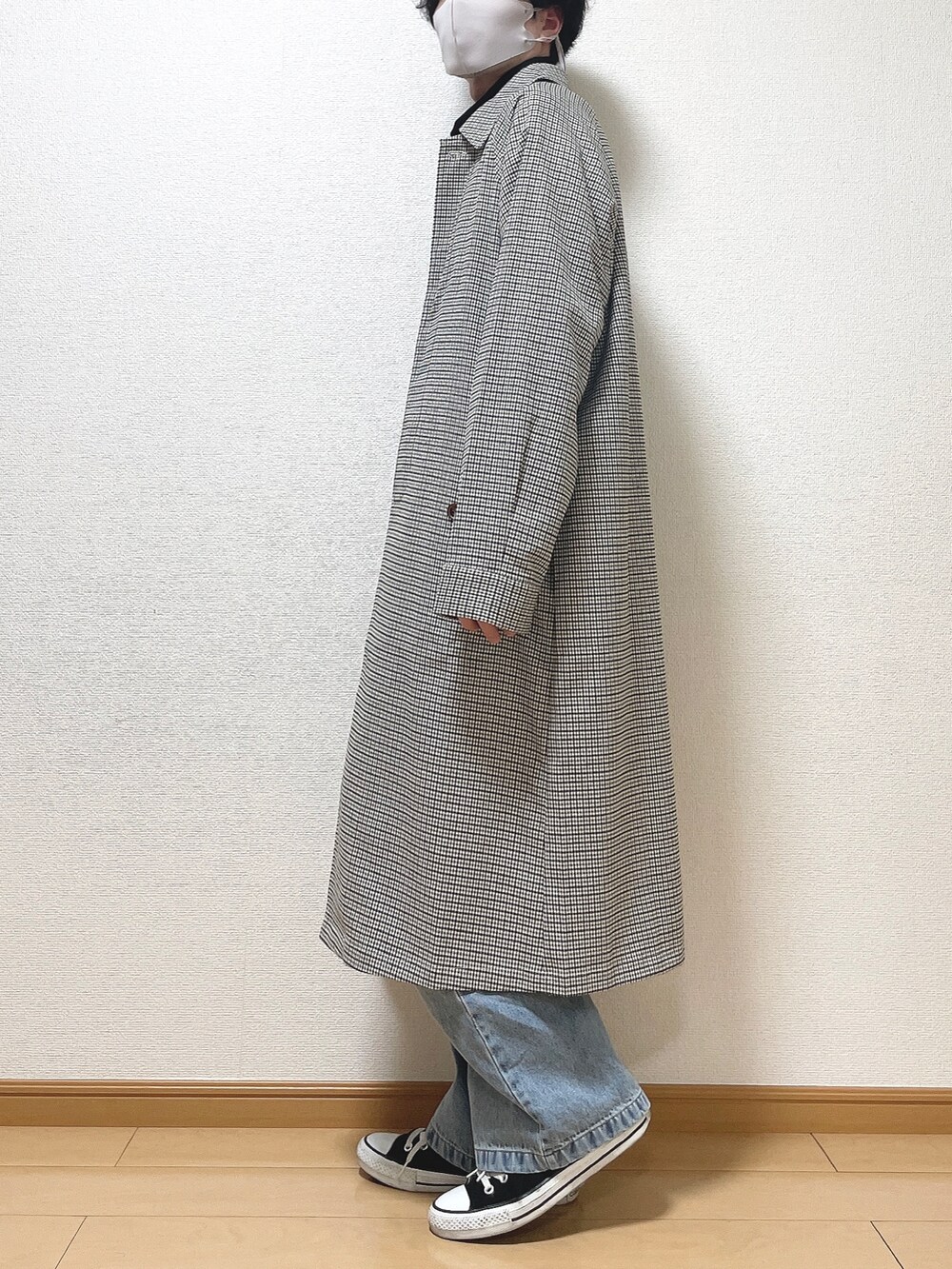 ホワイト系のステンカラーコート、ホワイト系のTシャツ/カットソー、ブルー系のデニムパンツを着用したメンズの春コーディネートの3枚目の写真