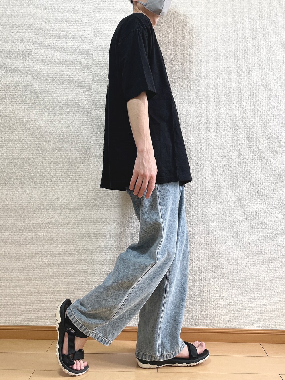 ブラック系のTシャツ/カットソー、ブルー系のデニムパンツ、ブラック系のサンダルを着用したメンズの夏コーディネートの3枚目の写真