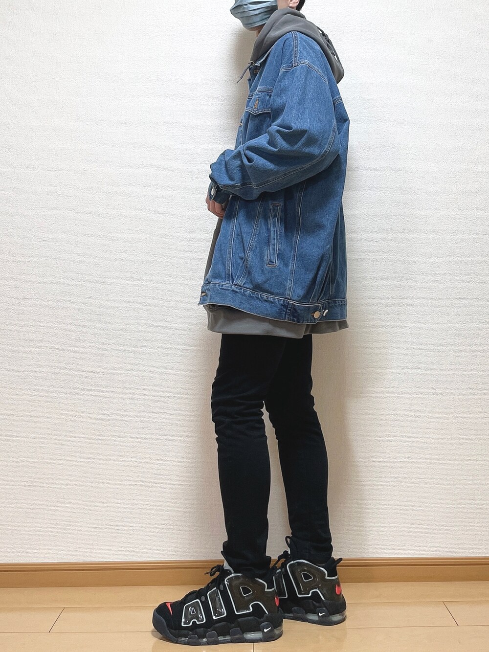 ブルー系のデニムジャケット、グレー系のパーカー、ブラック系のデニムパンツを着用したメンズの春コーディネートの3枚目の写真