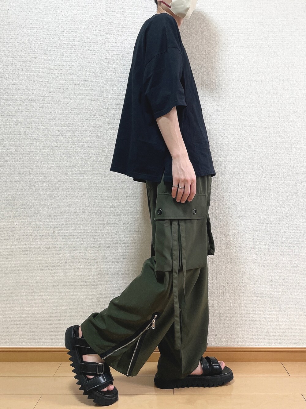 ブラック系のTシャツ/カットソー、グリーン系のカーゴパンツ、ブラック系のサンダルを着用したメンズの夏コーディネートの2枚目の写真