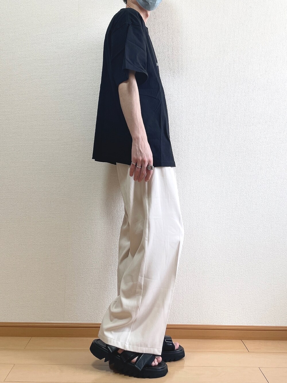 ブラック系のTシャツ/カットソー、ベージュ系のスラックス、ブラック系のサンダルを着用したメンズの夏コーディネートの2枚目の写真