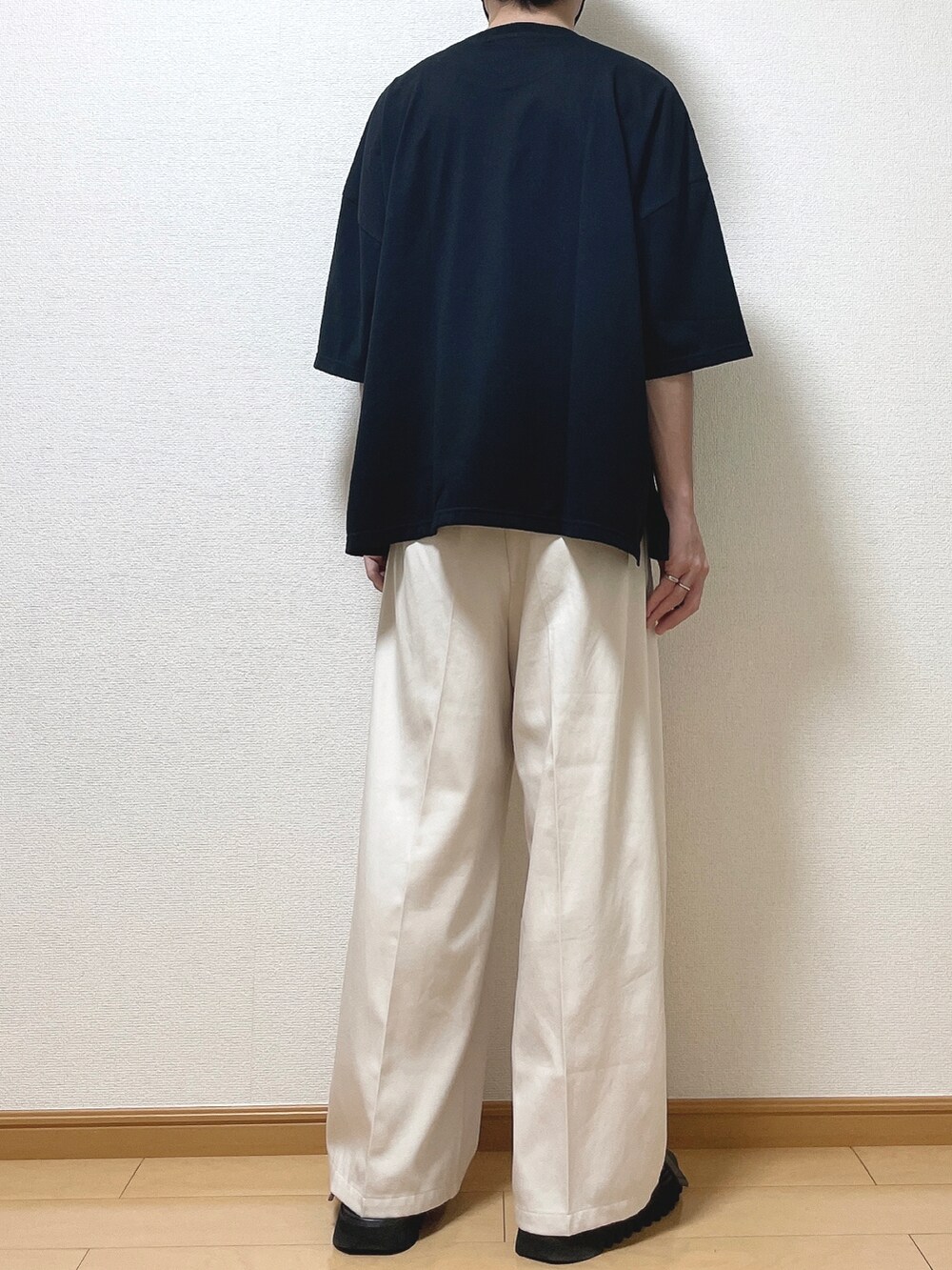 ブラック系のTシャツ/カットソー、ベージュ系のスラックス、ブラック系のサンダルを着用したメンズの夏コーディネートの4枚目の写真