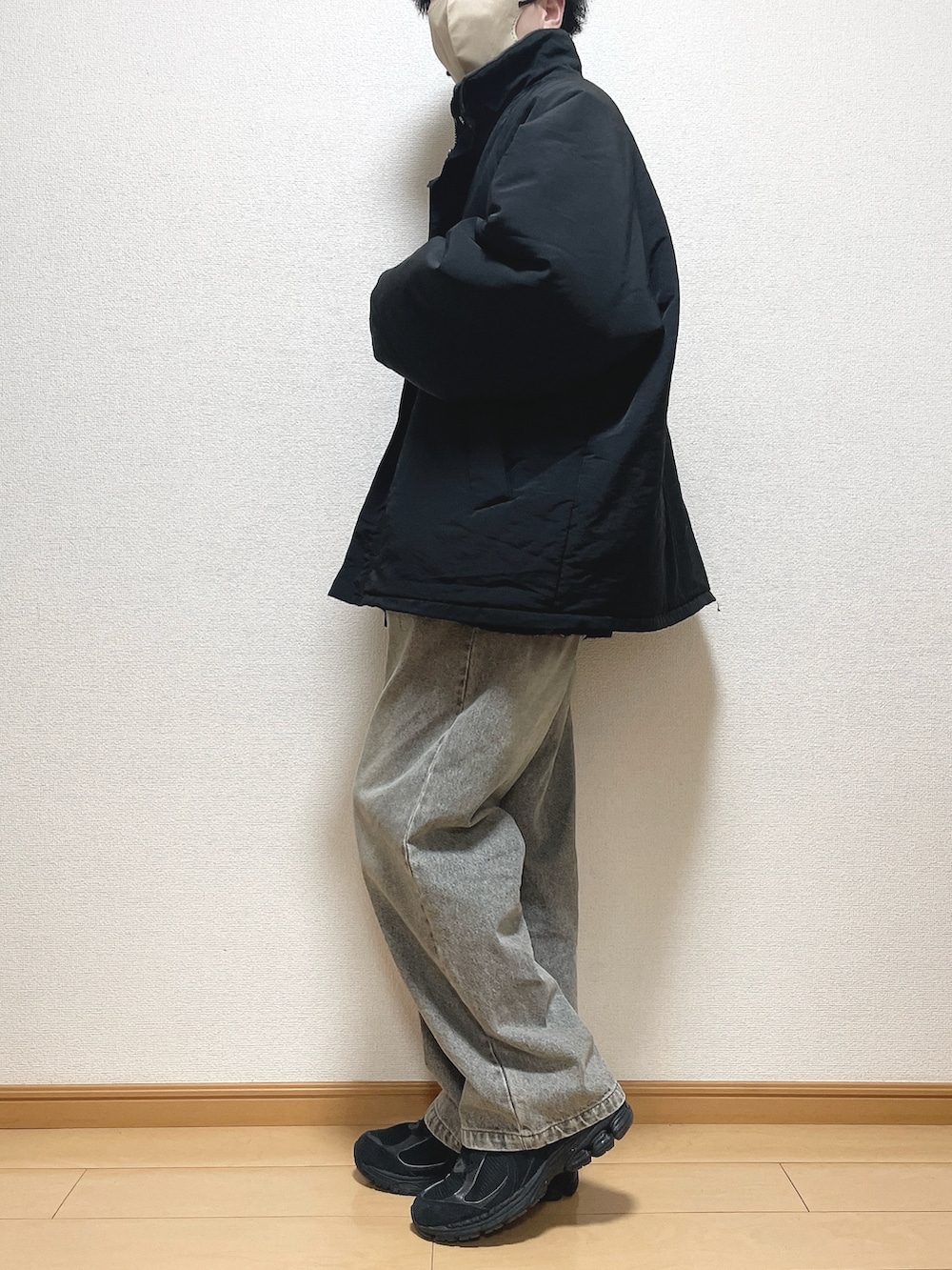 ブラック系のその他アウター、ベージュ系のニット/セーター、ブラック系のデニムパンツを着用したメンズの冬コーディネートの2枚目の写真