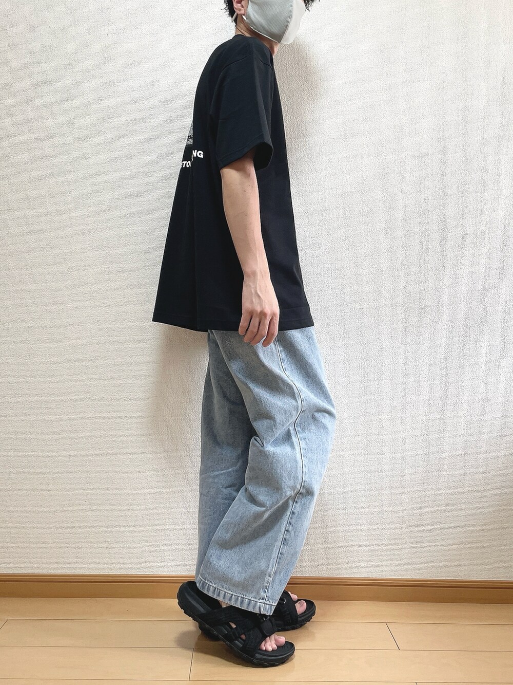 ブラック系のTシャツ/カットソー、ブルー系のデニムパンツ、ブラック系のサンダルを着用したメンズの夏コーディネートの2枚目の写真