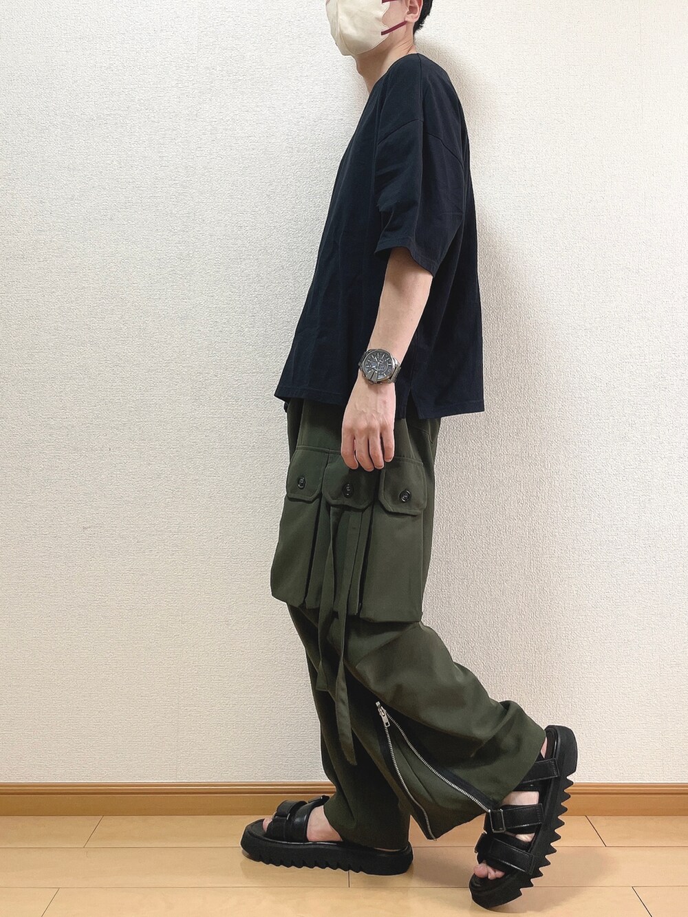 ブラック系のTシャツ/カットソー、グリーン系のカーゴパンツ、ブラック系のサンダルを着用したメンズの夏コーディネートの3枚目の写真