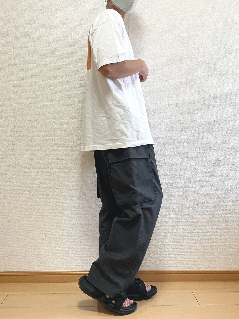 ホワイト系のTシャツ/カットソー、グレー系のカーゴパンツ、ブラック系のサンダルを着用したメンズの夏コーディネートの2枚目の写真