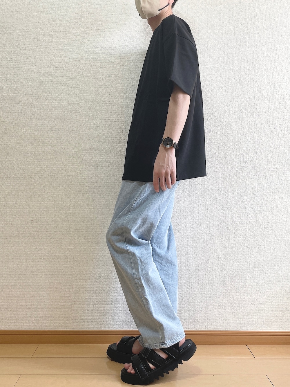 ブラック系のTシャツ/カットソー、ブルー系のデニムパンツ、ブラック系のサンダルを着用したメンズの春コーディネートの3枚目の写真