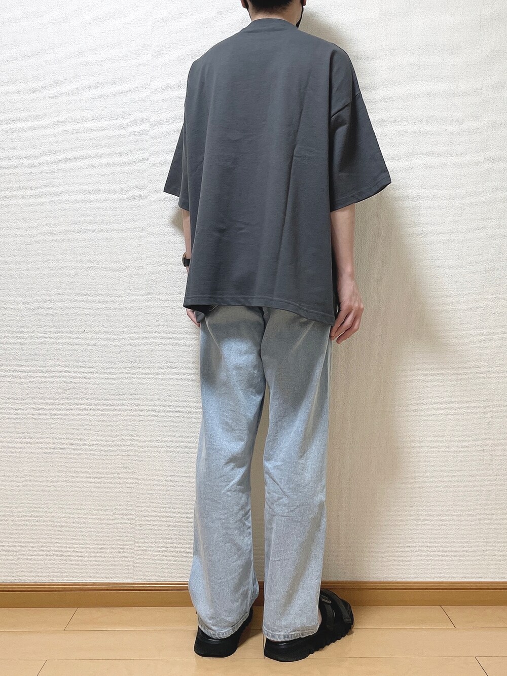 グレー系のTシャツ/カットソー、ブルー系のデニムパンツ、ブラック系のサンダルを着用したメンズの夏コーディネートの4枚目の写真