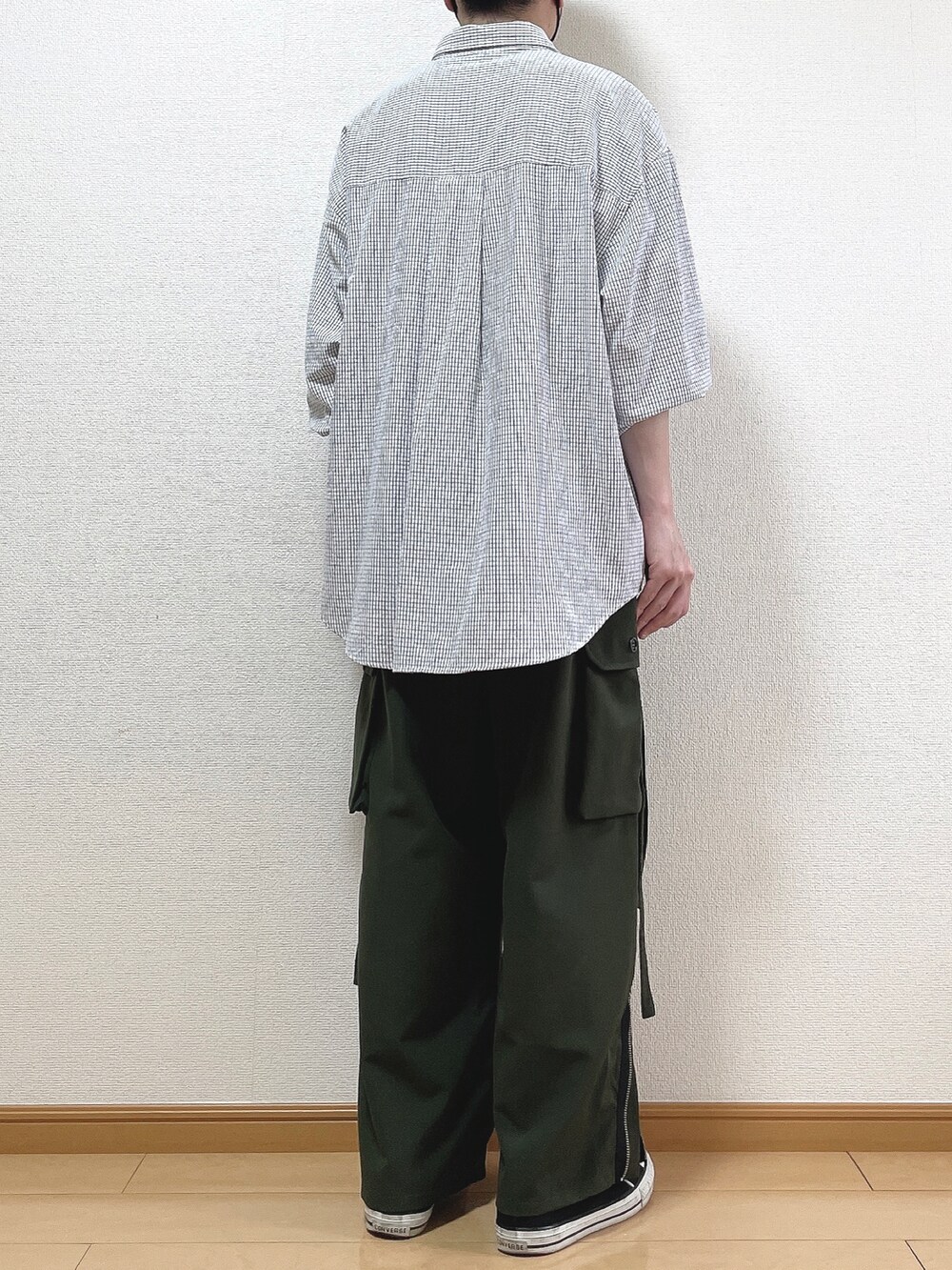 ブラック系のシャツ/ブラウス、グリーン系のカーゴパンツ、ブラック系のスニーカーを着用したメンズの春コーディネートの4枚目の写真