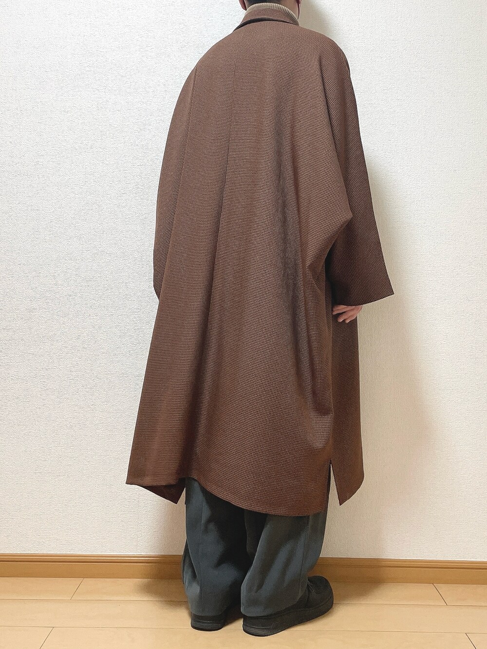 ブラウン系のステンカラーコート、ベージュ系のニット/セーター、グレー系のスラックスを着用したメンズの冬コーディネートの4枚目の写真