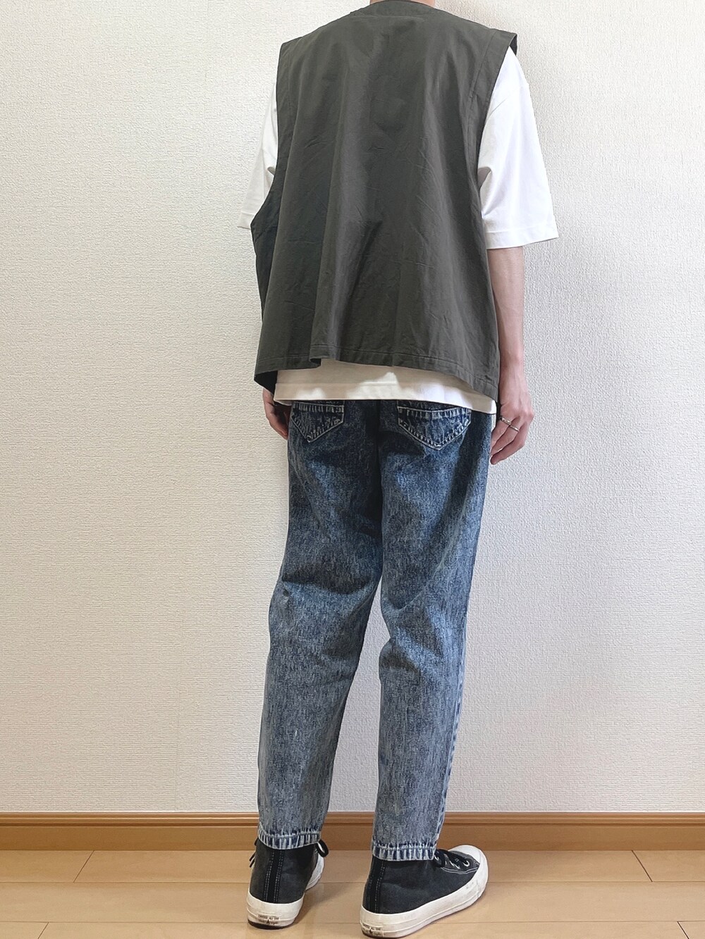グレー系のベスト、ホワイト系のTシャツ/カットソー、ブルー系のデニムパンツを着用したメンズの夏コーディネートの4枚目の写真