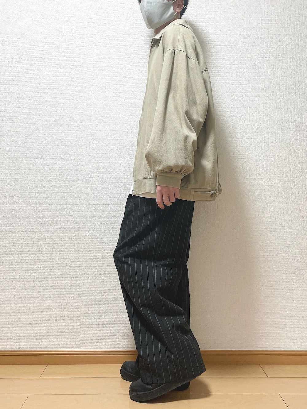 ベージュ系のブルゾン、ホワイト系のTシャツ/カットソー、ブラック系のパンツを着用したメンズの春コーディネートの3枚目の写真