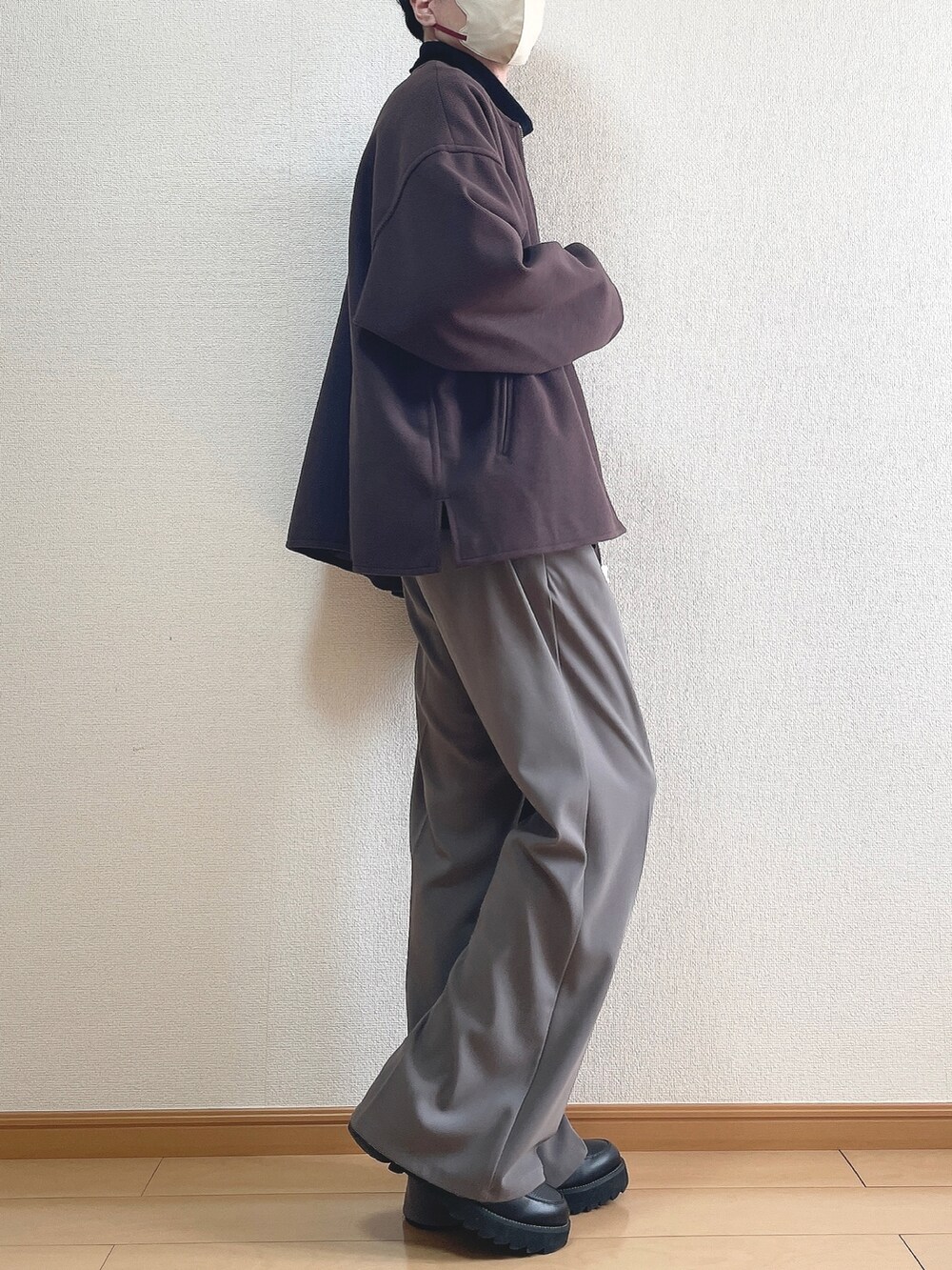 レッド系のブルゾン、ホワイト系のTシャツ/カットソー、ブラウン系のスラックスを着用したメンズの春コーディネートの2枚目の写真