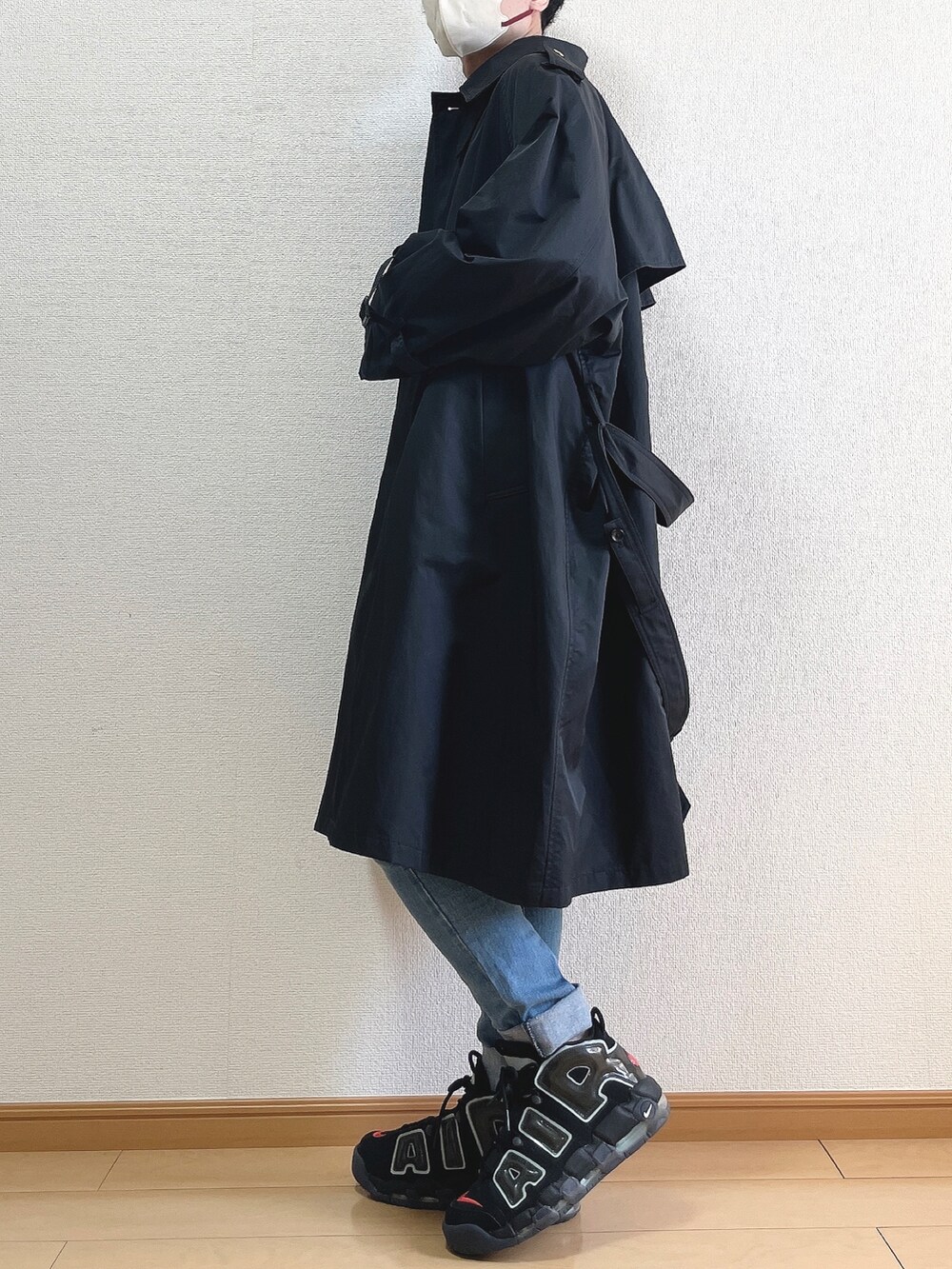 ブラック系のトレンチコート、ホワイト系のシャツ/ブラウス、ブルー系のデニムパンツを着用したメンズの春コーディネートの3枚目の写真