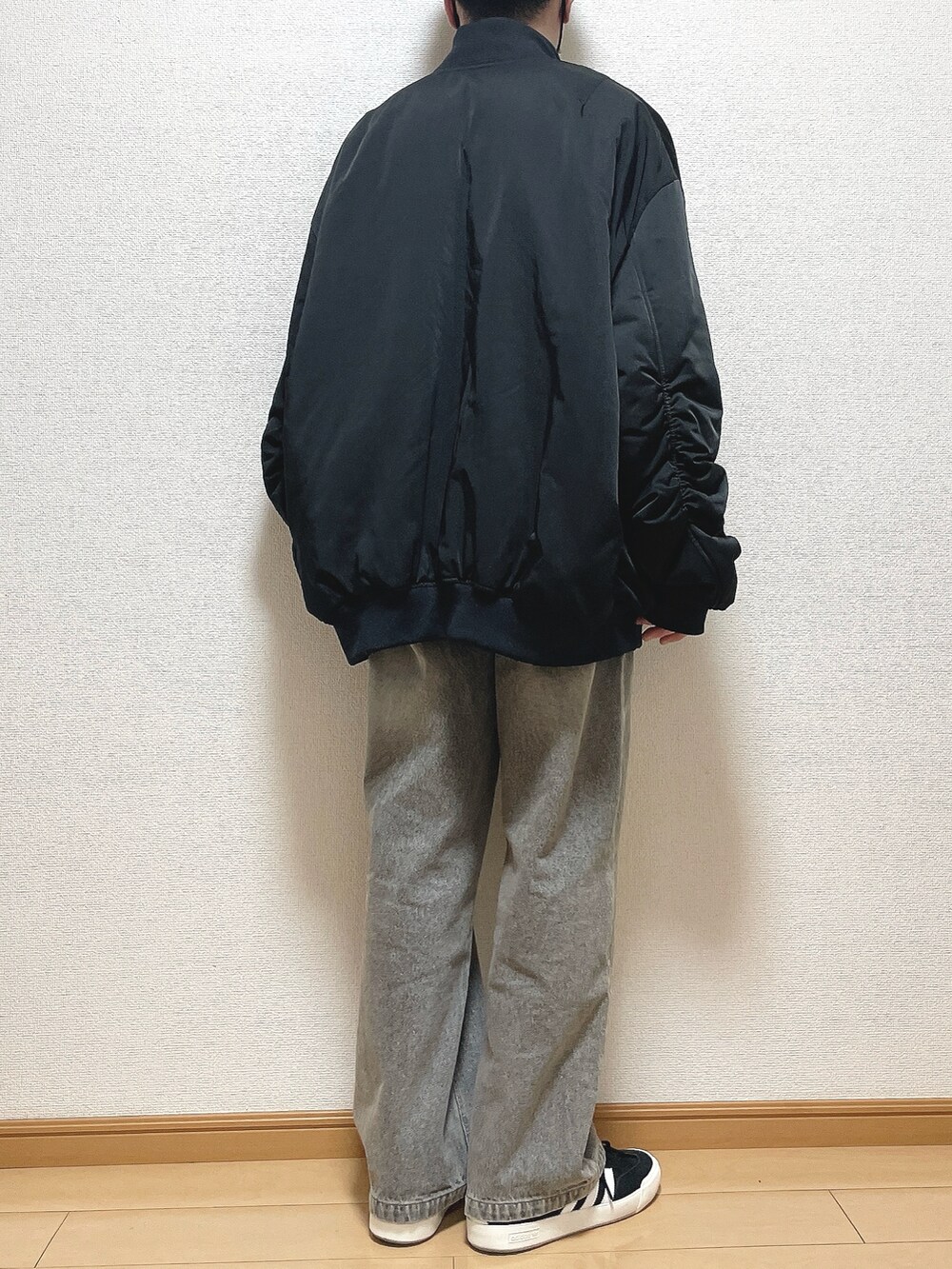 ブラック系のMA-1、グレー系のTシャツ/カットソー、ブルー系のデニムパンツを着用したメンズの冬コーディネートの4枚目の写真