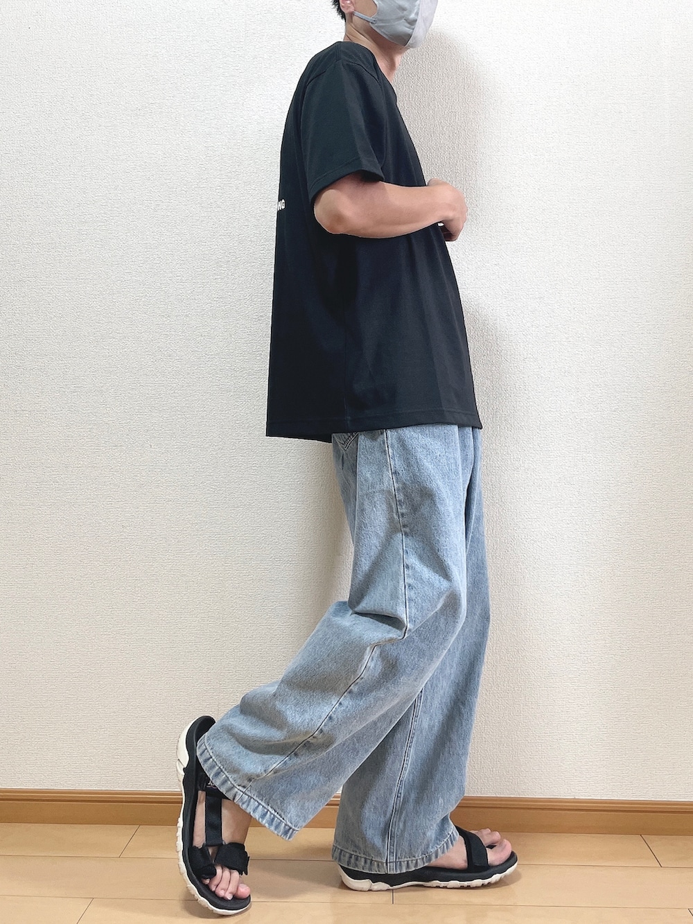 ブラック系のTシャツ/カットソー、ブルー系のデニムパンツ、ブラック系のサンダルを着用したメンズの夏コーディネートの2枚目の写真