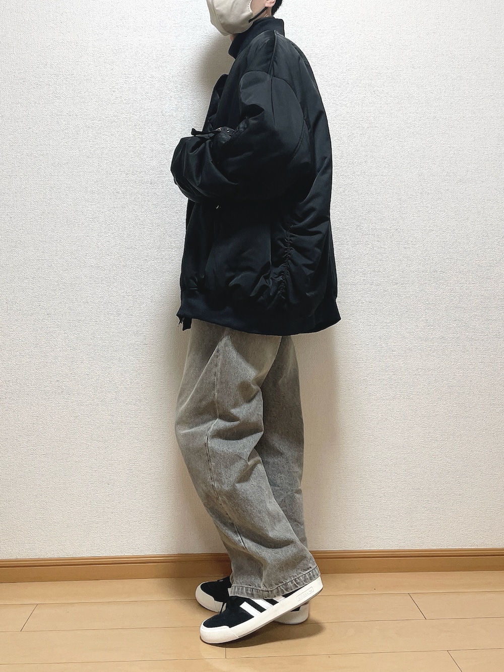 ブラック系のMA-1、グレー系のTシャツ/カットソー、ブルー系のデニムパンツを着用したメンズの冬コーディネートの2枚目の写真