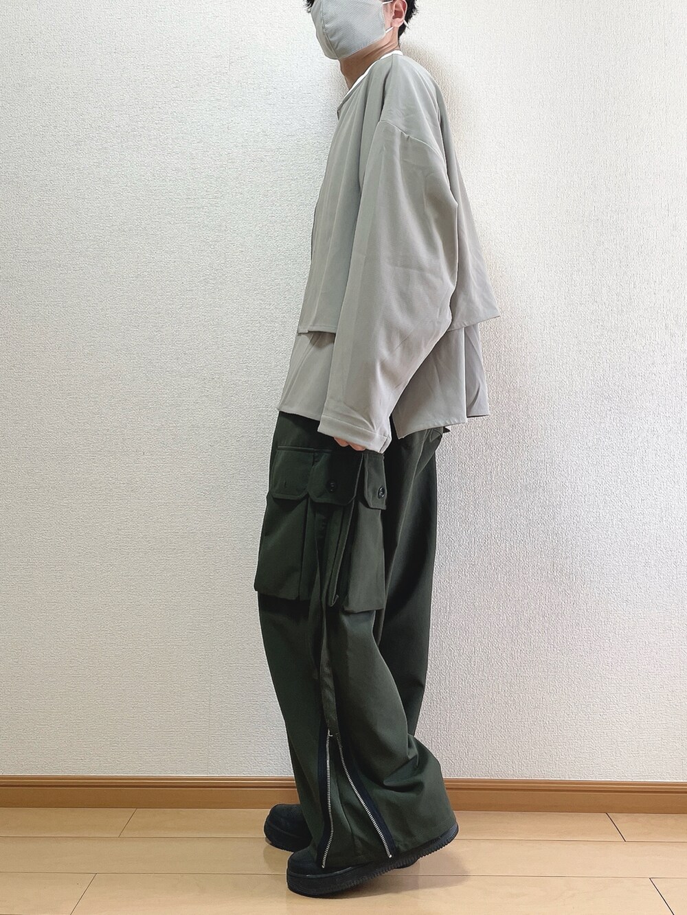 グレー系のブルゾン、ホワイト系のTシャツ/カットソー、グリーン系のカーゴパンツを着用したメンズの春コーディネートの3枚目の写真