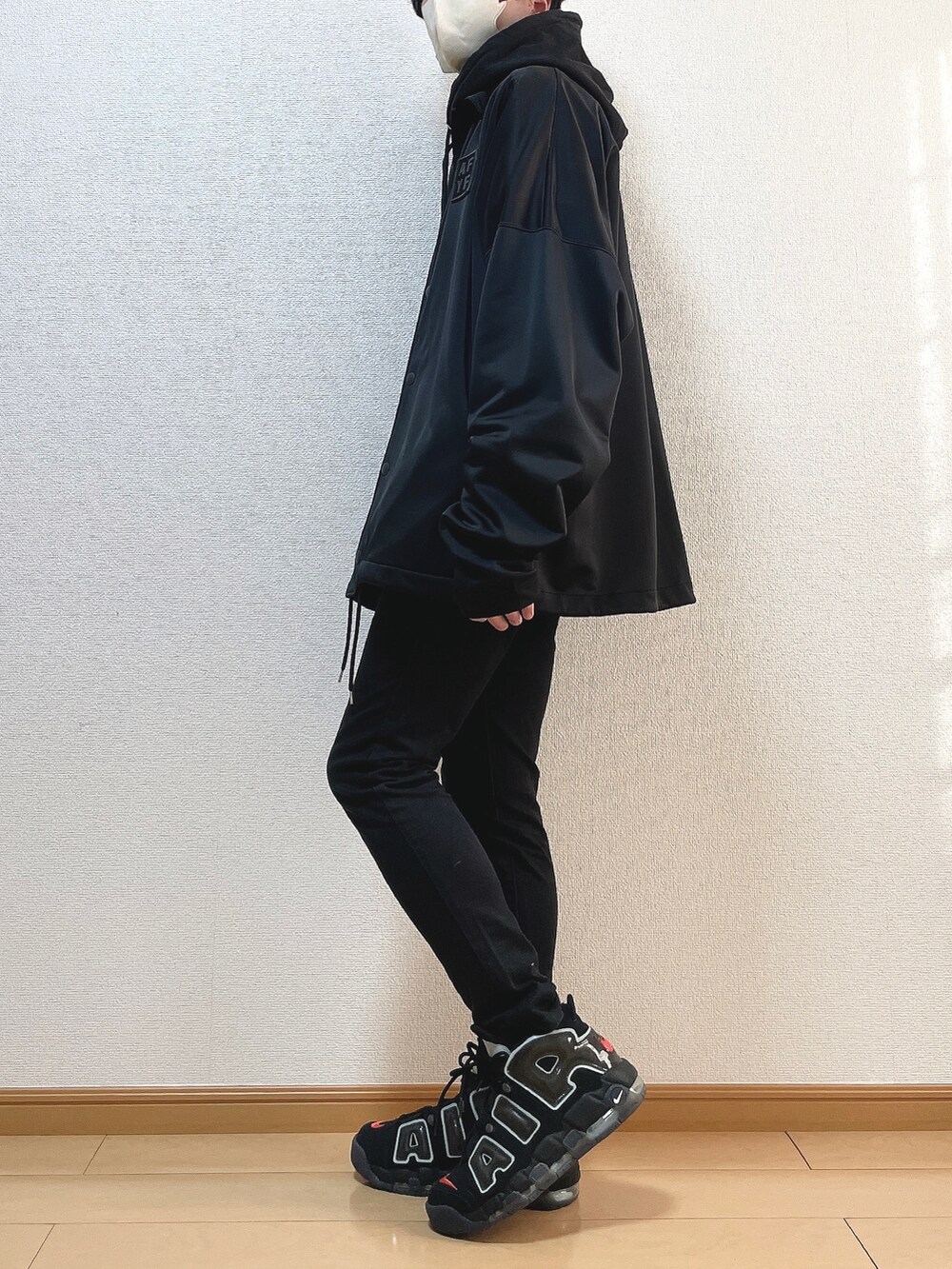 ブラック系のブルゾン、ブラック系のパーカー、ブラック系のデニムパンツを着用したメンズの冬コーディネートの3枚目の写真