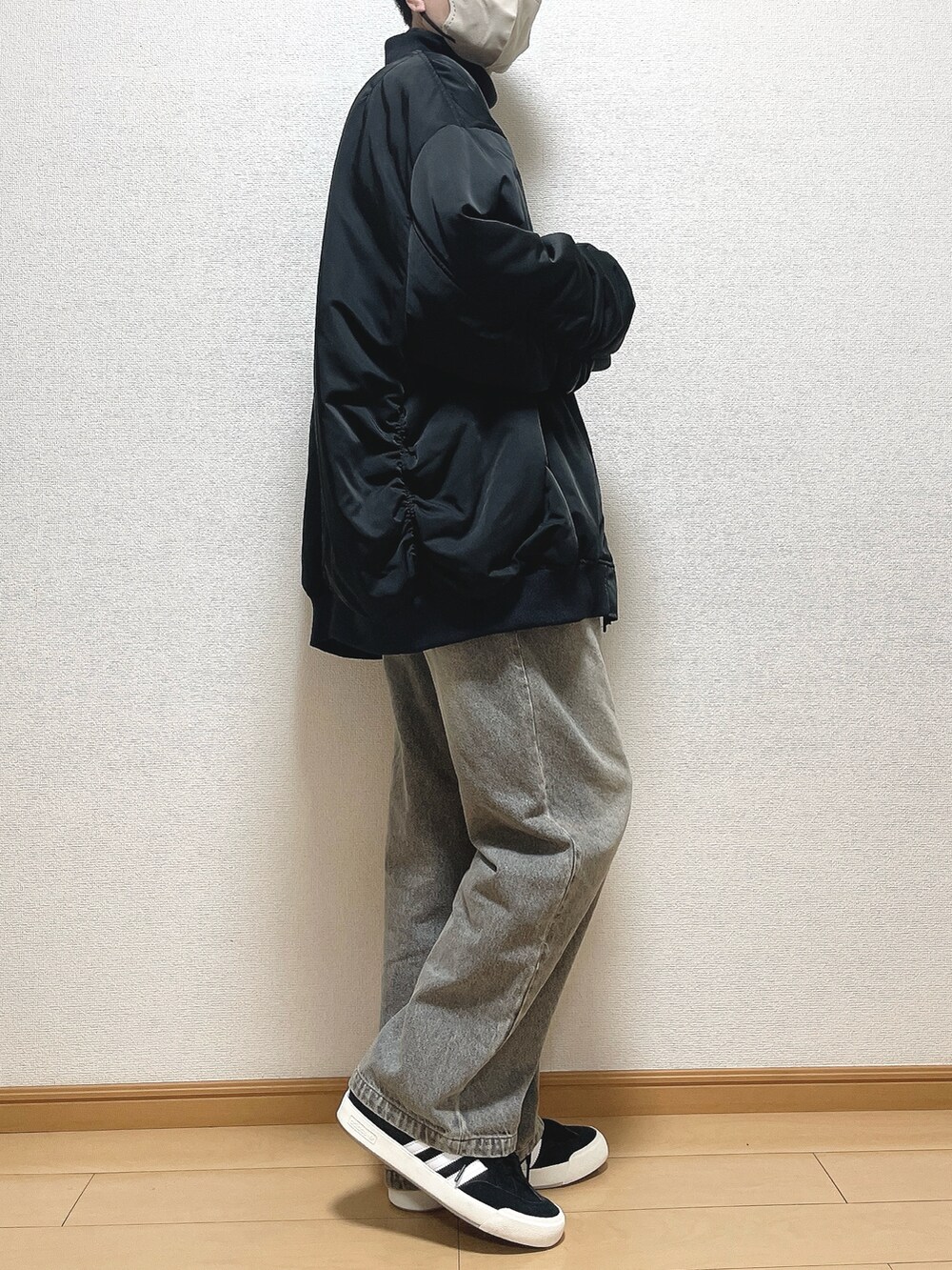 ブラック系のMA-1、グレー系のTシャツ/カットソー、ブルー系のデニムパンツを着用したメンズの冬コーディネートの3枚目の写真