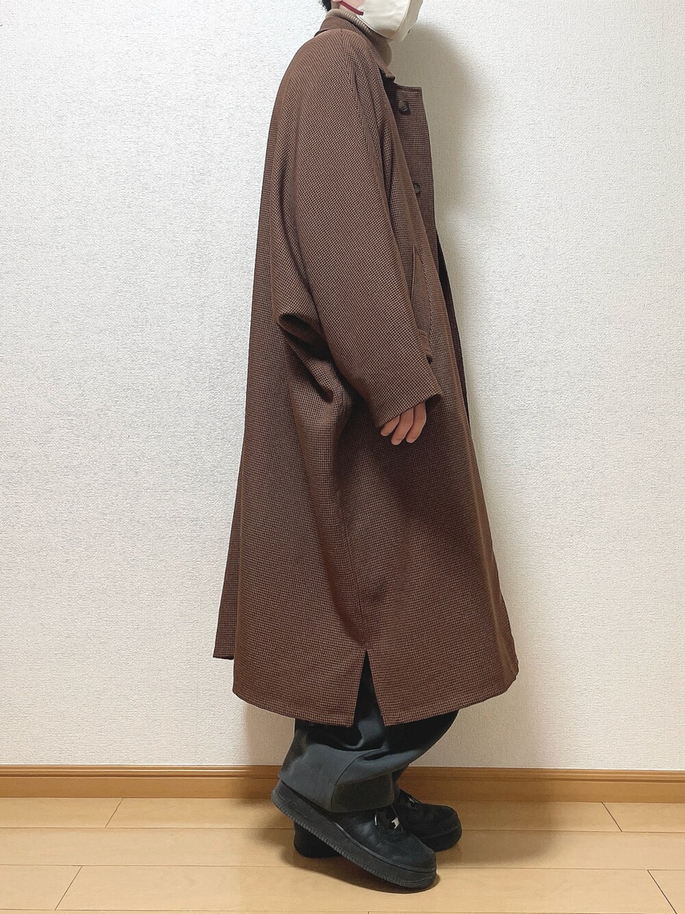 ブラウン系のステンカラーコート、ベージュ系のニット/セーター、グレー系のスラックスを着用したメンズの冬コーディネートの2枚目の写真