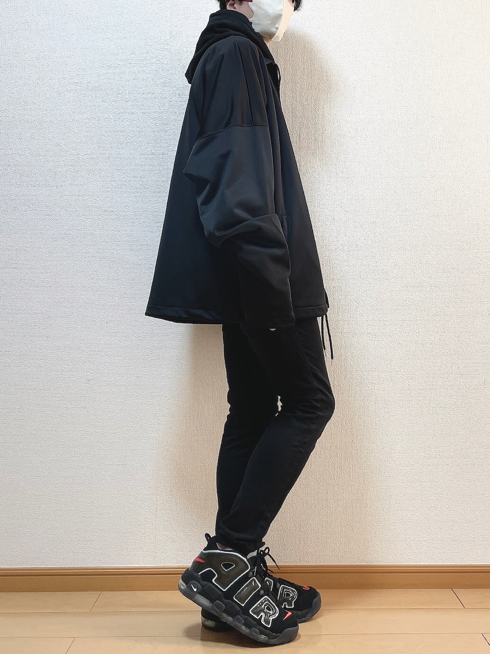 ブラック系のブルゾン、ブラック系のパーカー、ブラック系のデニムパンツを着用したメンズの冬コーディネートの2枚目の写真