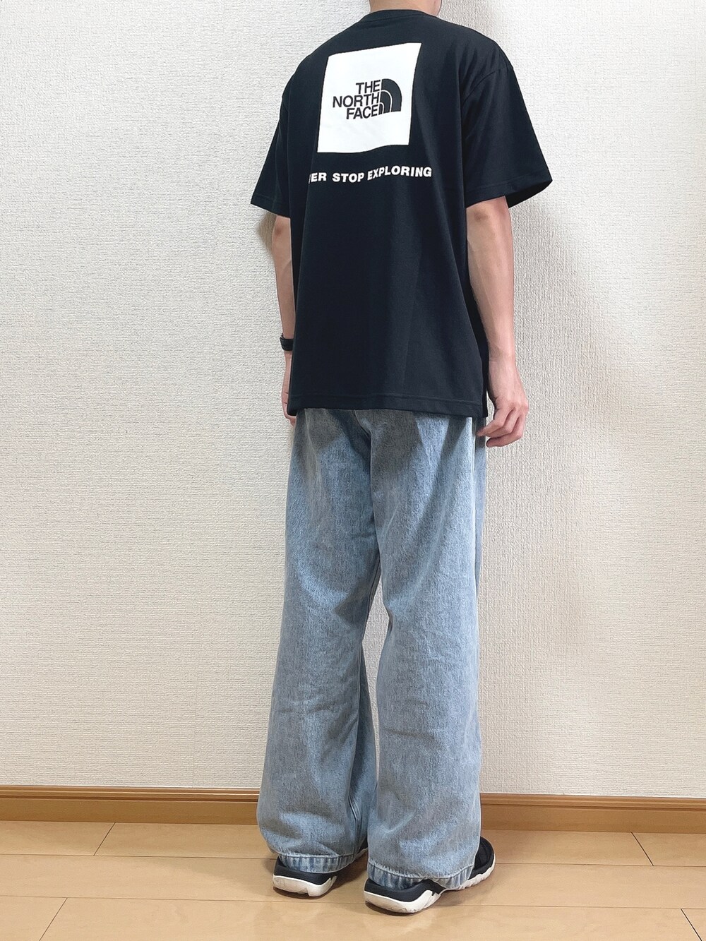 ブラック系のTシャツ/カットソー、ブルー系のデニムパンツ、ブラック系のサンダルを着用したメンズの夏コーディネートの4枚目の写真