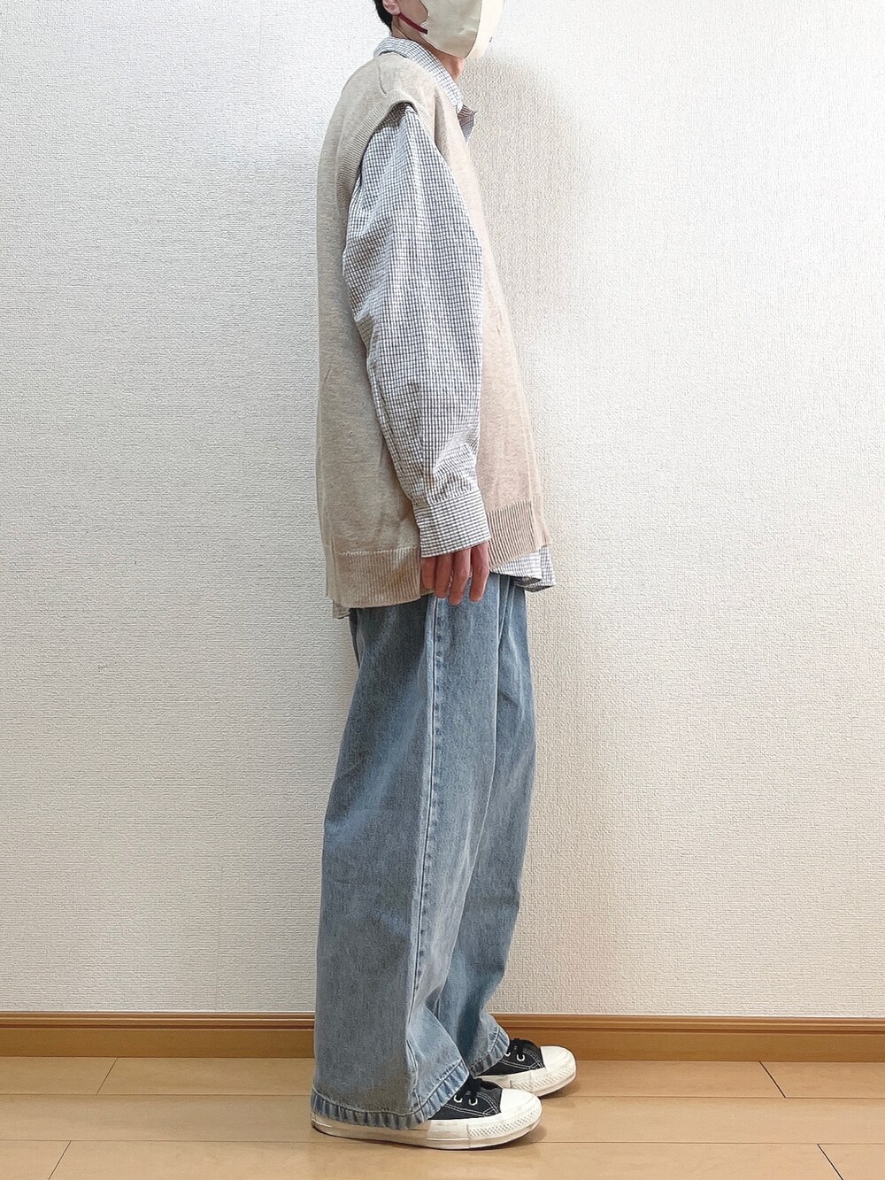 ベージュ系のニット/セーター、ブラック系のシャツ/ブラウス、ブルー系のデニムパンツを着用したメンズの春コーディネートの2枚目の写真