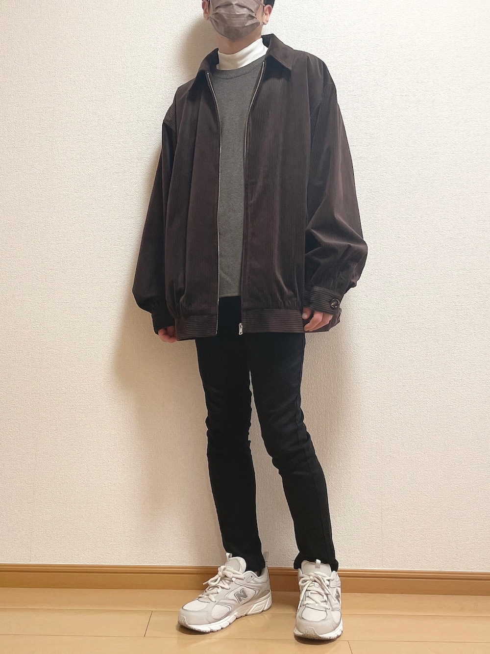 ブラウン系のブルゾン、ブラウン系のニット/セーター、ホワイト系のTシャツ/カットソーを着用したメンズの秋コーディネートの2枚目の写真