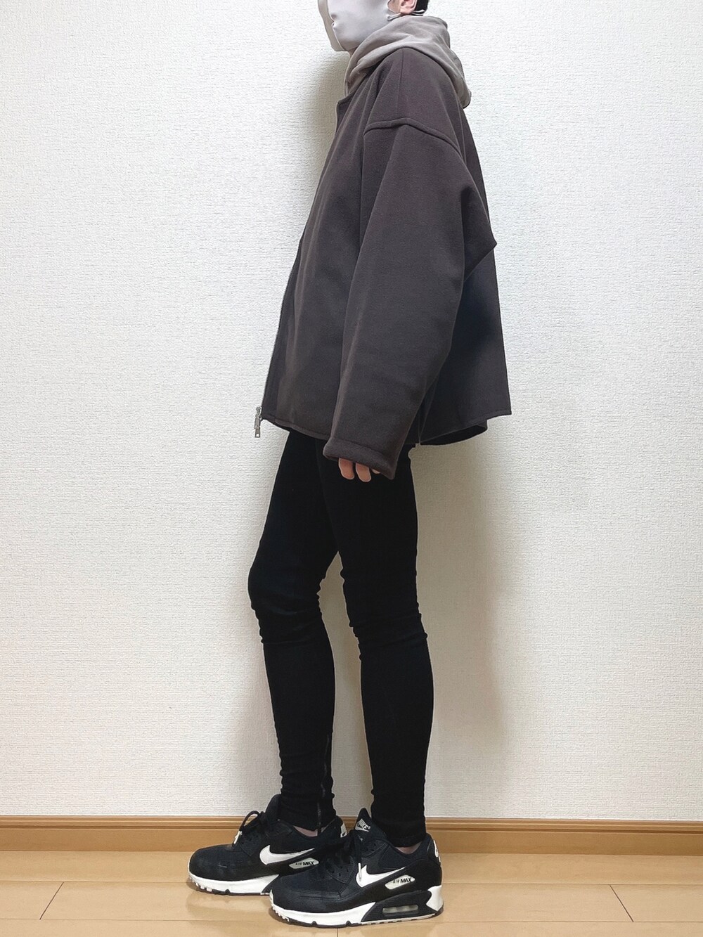 レッド系のブルゾン、ブラウン系のパーカー、ブラック系のTシャツ/カットソーを着用したメンズの冬コーディネートの2枚目の写真