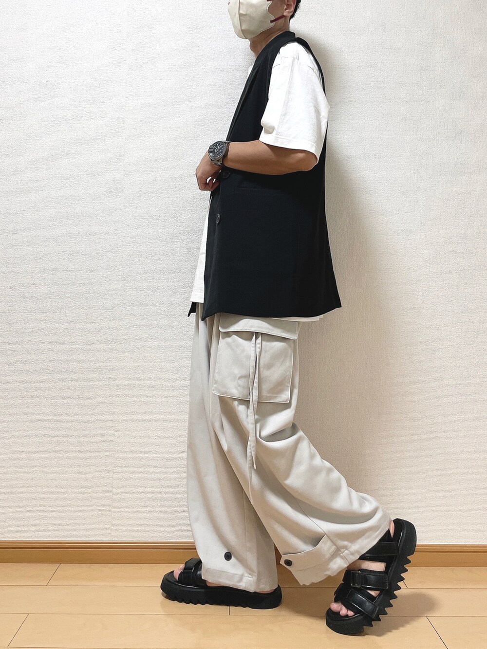 ブラック系のベスト、ホワイト系のTシャツ/カットソー、グレー系のカーゴパンツを着用したメンズの秋コーディネートの3枚目の写真