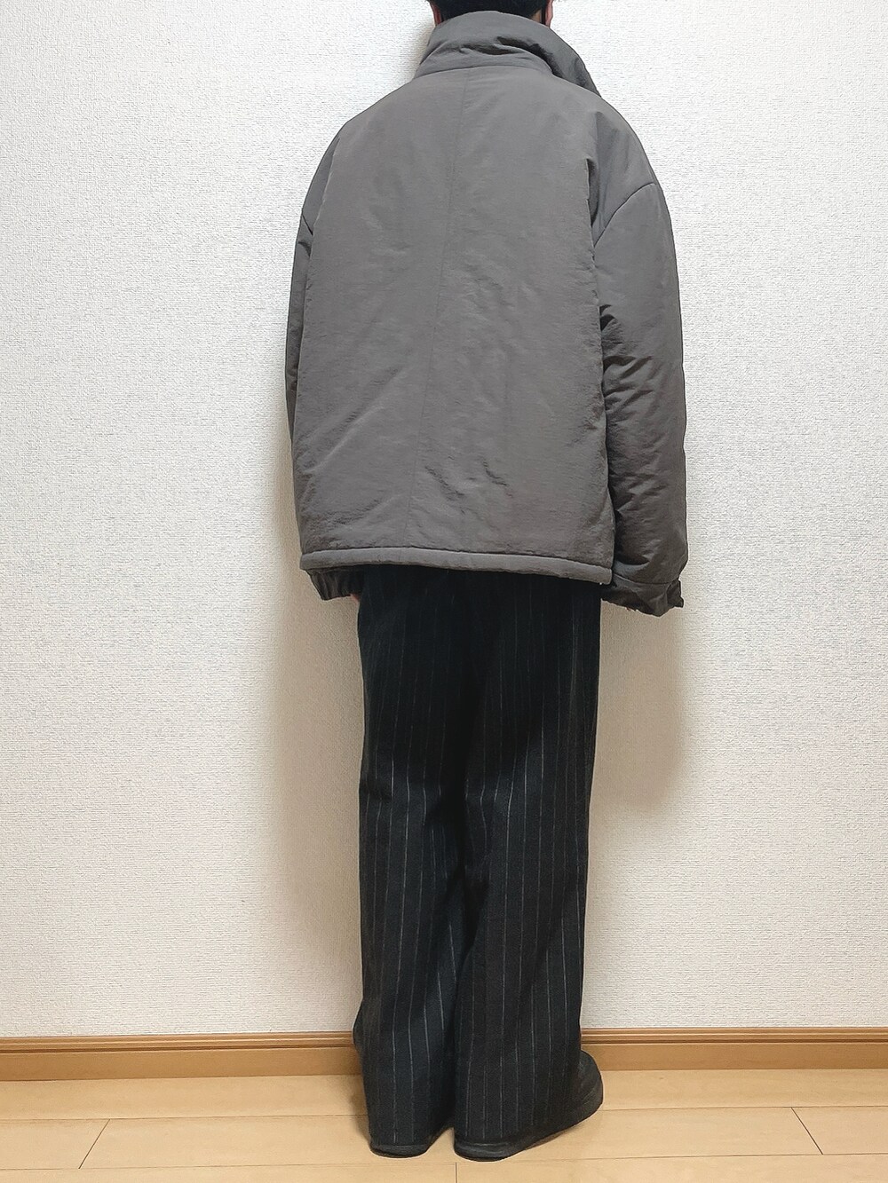 ブラウン系のその他アウター、ブラック系のニット/セーター、ブラック系のパンツを着用したメンズの冬コーディネートの4枚目の写真