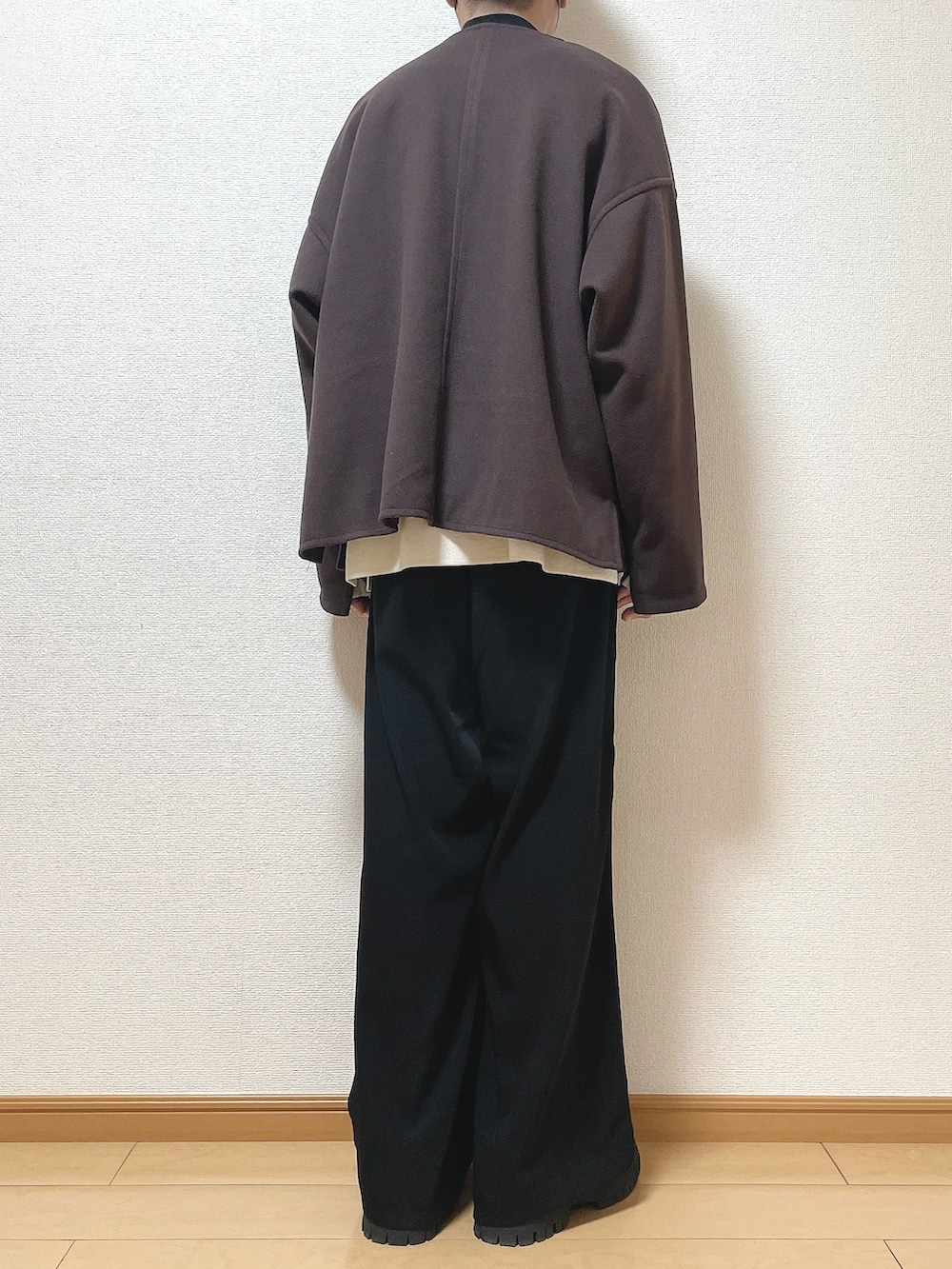 レッド系のブルゾン、ホワイト系のニット/セーター、ブラック系のTシャツ/カットソーを着用したメンズの冬コーディネートの4枚目の写真