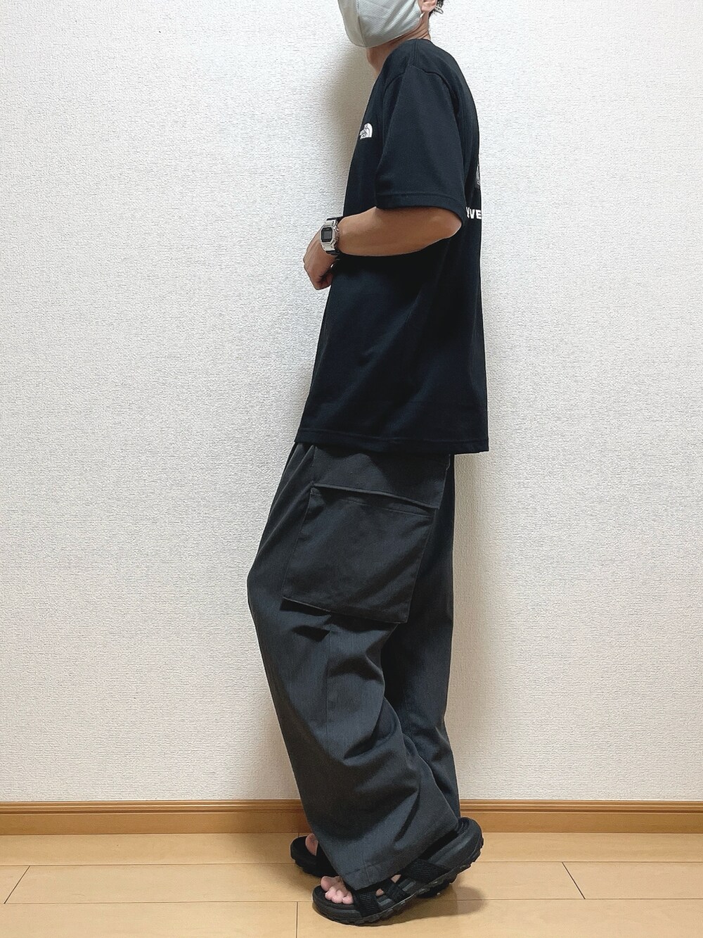 ブラック系のTシャツ/カットソー、グレー系のカーゴパンツ、ブラック系のサンダルを着用したメンズの夏コーディネートの3枚目の写真