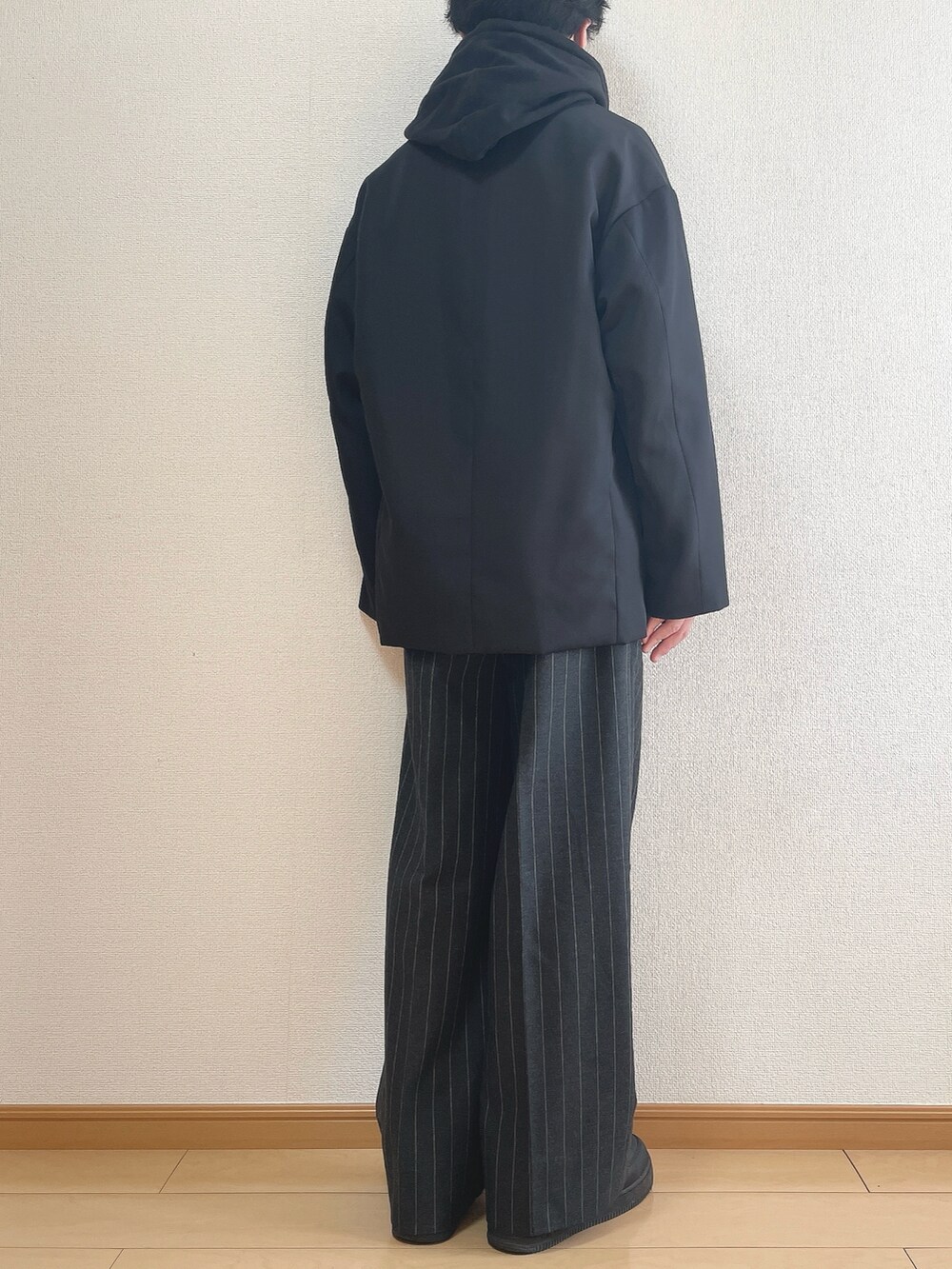 ブラック系のテーラードジャケット、ブラック系のパーカー、ブラック系のパンツを着用したメンズの冬コーディネートの4枚目の写真