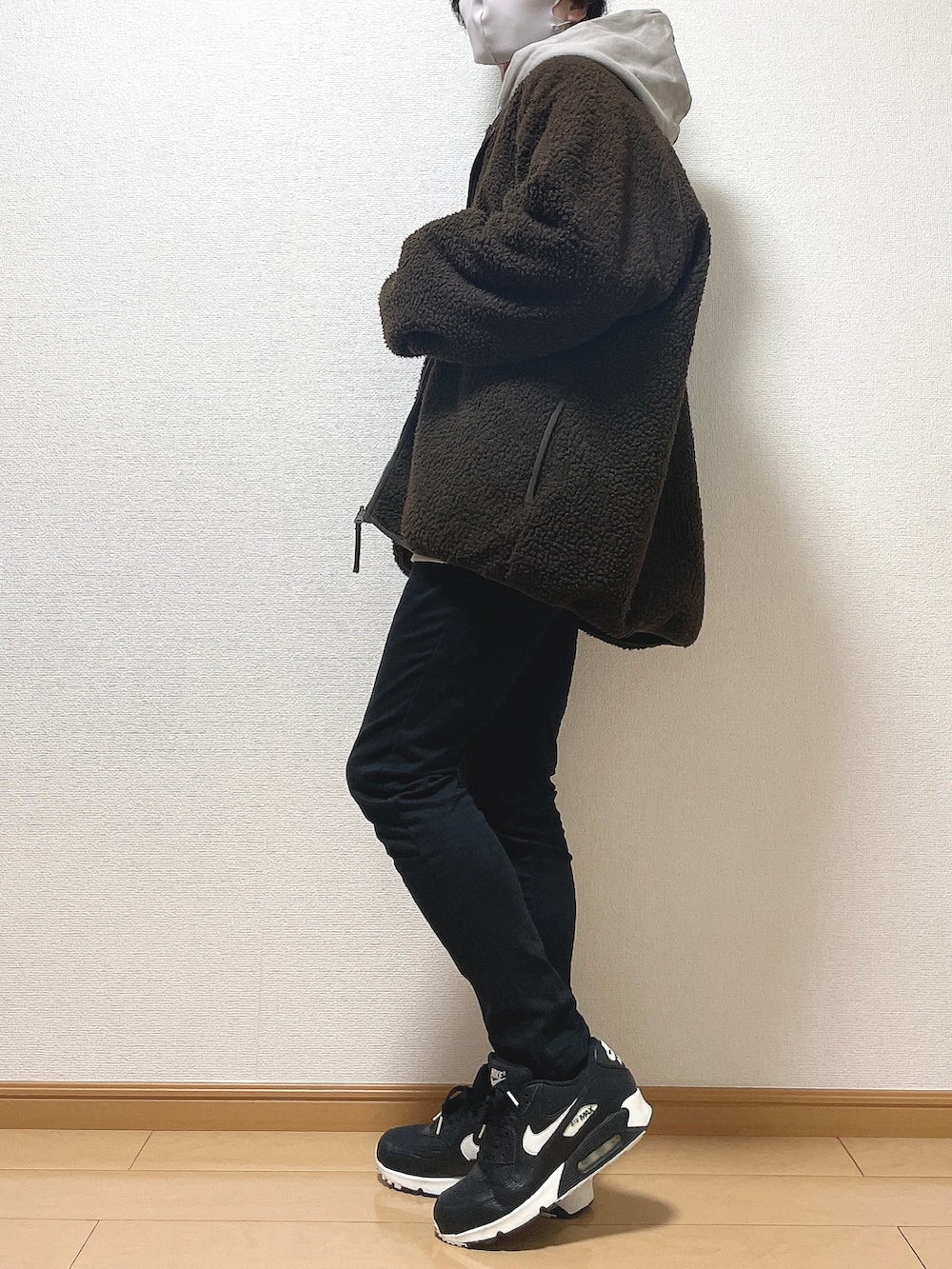 ブラウン系のブルゾン、ベージュ系のパーカー、ブラック系のデニムパンツを着用したメンズの冬コーディネートの3枚目の写真