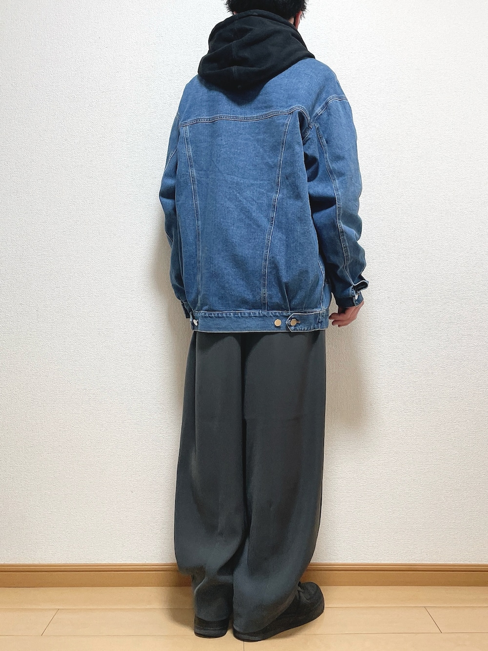 ブラック系のパーカー、グレー系のスラックス、ブラック系のスニーカーを着用したメンズの春コーディネートの4枚目の写真