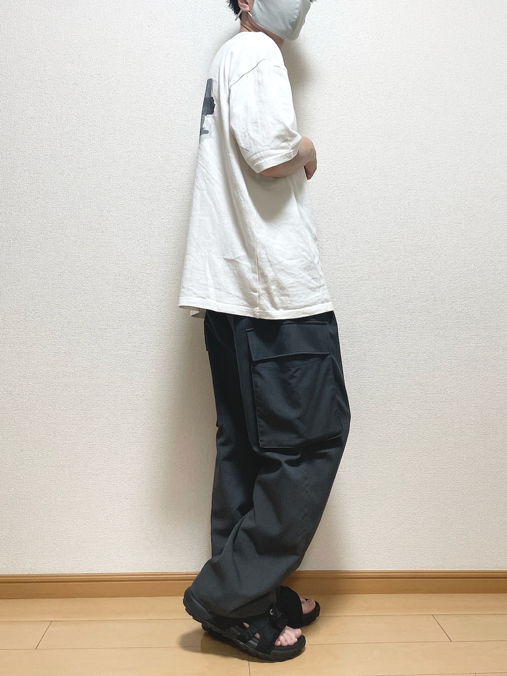 グレー系のカーゴパンツ、グリーン系のTシャツ/カットソー、ブラック系のサンダルを着用したメンズの夏コーディネートの2枚目の写真