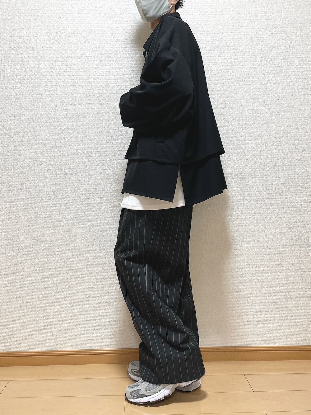 ブラック系のブルゾン、ホワイト系のTシャツ/カットソー、ブラック系のパンツを着用したメンズの秋コーディネートの3枚目の写真