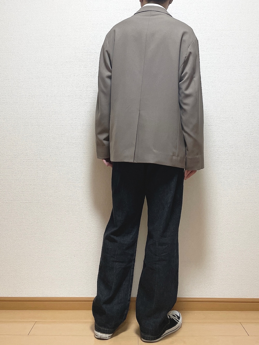 ベージュ系のセットアップ、ホワイト系のTシャツ/カットソー、ブラック系のデニムパンツを着用したメンズの春コーディネートの4枚目の写真