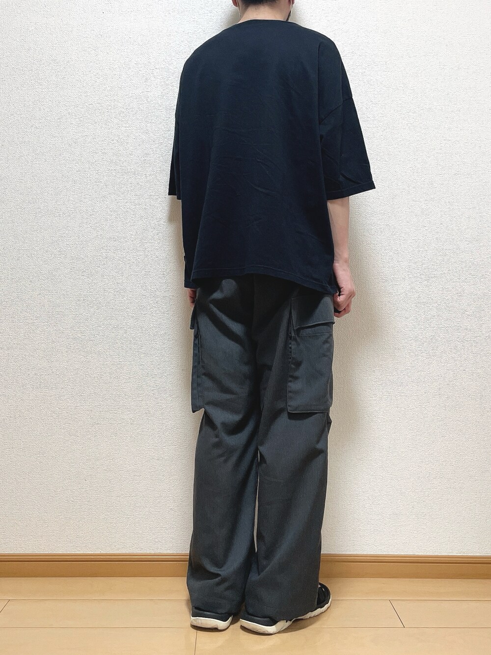 ブラック系のTシャツ/カットソー、グレー系のカーゴパンツ、ブラック系のサンダルを着用したメンズの夏コーディネートの4枚目の写真