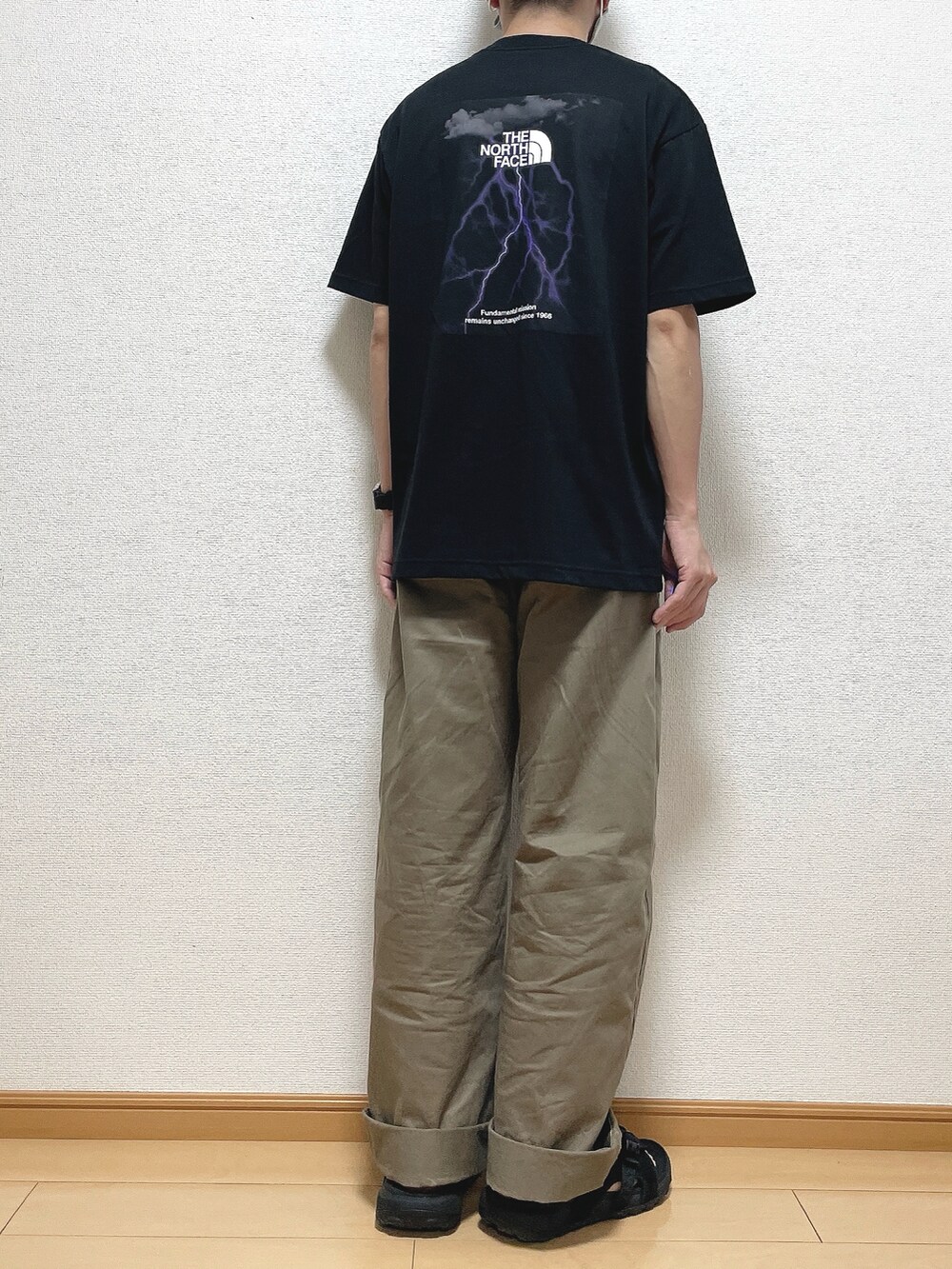 ブラック系のTシャツ/カットソー、ベージュ系のその他パンツ、ブラック系のサンダルを着用したメンズの夏コーディネートの4枚目の写真